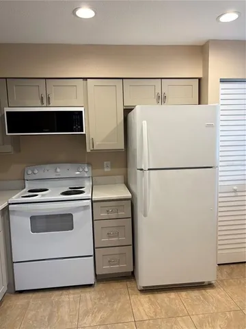 a kitchen with a refrigerator and a stove