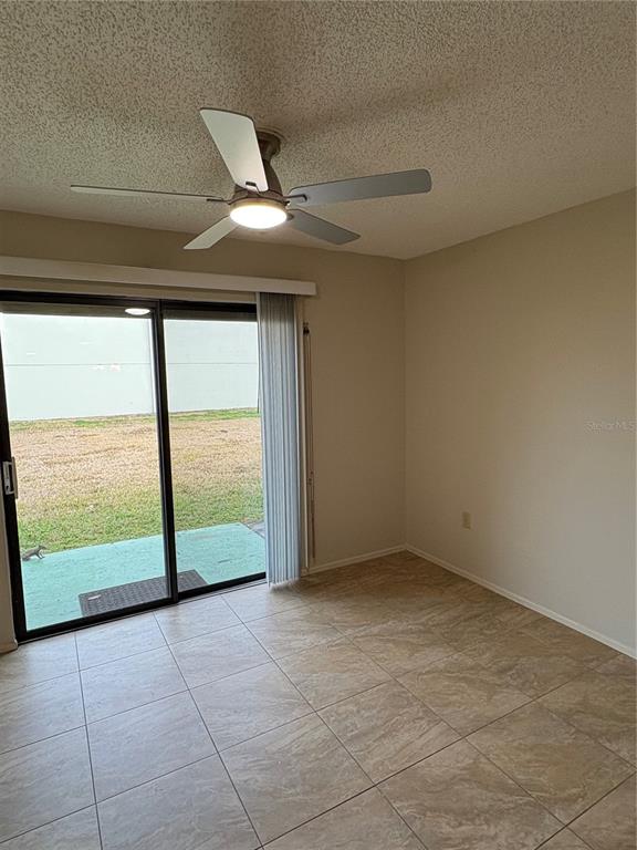 13250 Ridge Road, Unit 16 Largo, FL 33778 - Photo 17 of 32 a view of an empty room with a floor to ceiling window and a ceiling fan