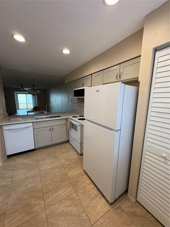 13250 Ridge Road, Unit 16 Largo, FL 33778 - Photo 5 of 28 a kitchen with cabinets a sink and white stainless steel appliances