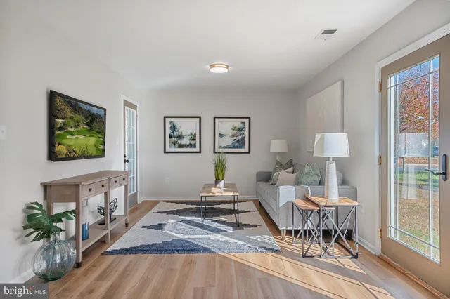 a kitchen with stainless steel appliances granite countertop a refrigerator a sink dishwasher a stove and a dining table with wooden floor