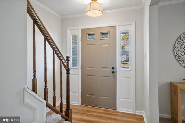 a view of a hallway with wooden floor and staircase