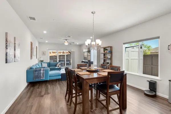 a living room with furniture kitchen view and a large window