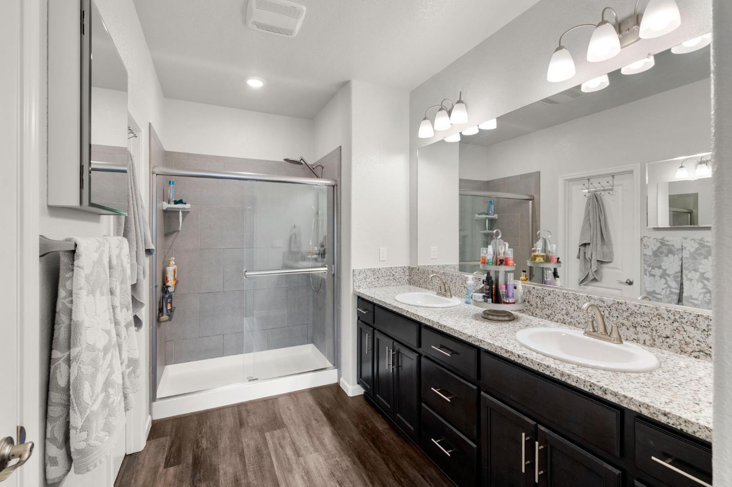 1500 Lahonton Way Ione, CA 95640 - Photo 27 of 52 a bathroom with a granite countertop sink a large mirror a shower and a bathtub