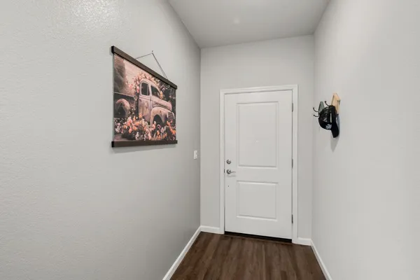 a kitchen with granite countertop a refrigerator and wooden cabinets
