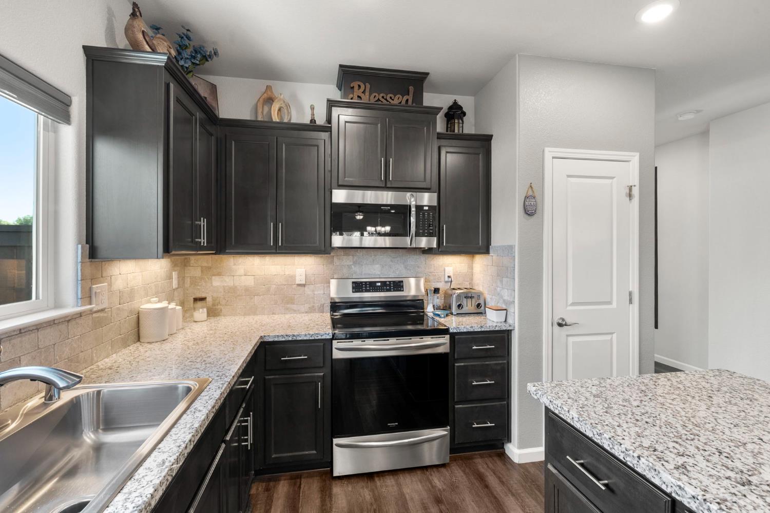 1500 Lahonton Way Ione, CA 95640 - Photo 9 of 52 a kitchen with granite countertop a stove and a sink
