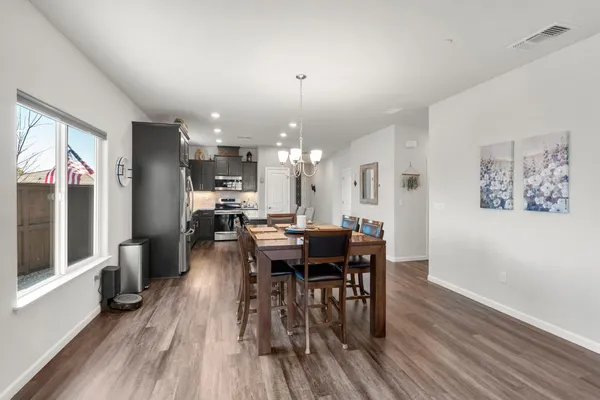a kitchen with granite countertop kitchen island a table and chairs in it