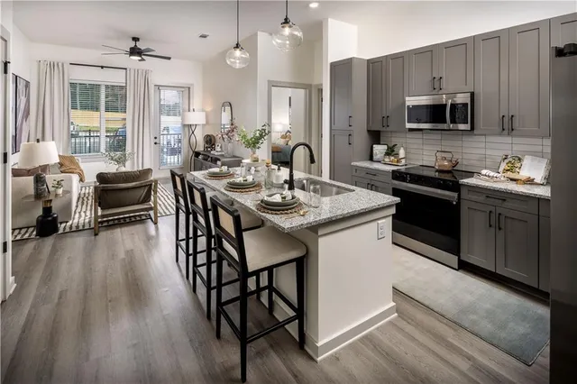 a kitchen with stainless steel appliances granite countertop a dining table and chairs