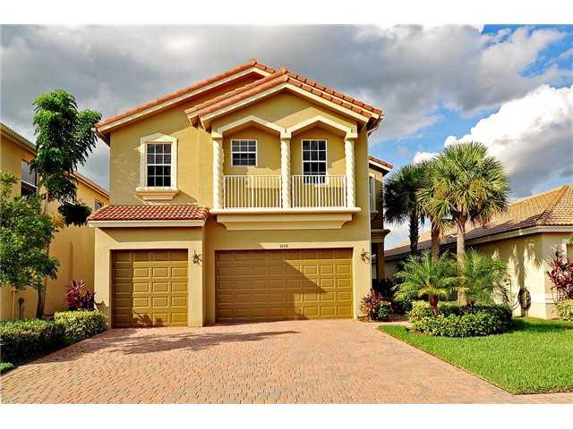 3152 Southwest Porpoise Circle Stuart, FL 34997 - Photo 2 of 19 a front view of a house with a garden and garage