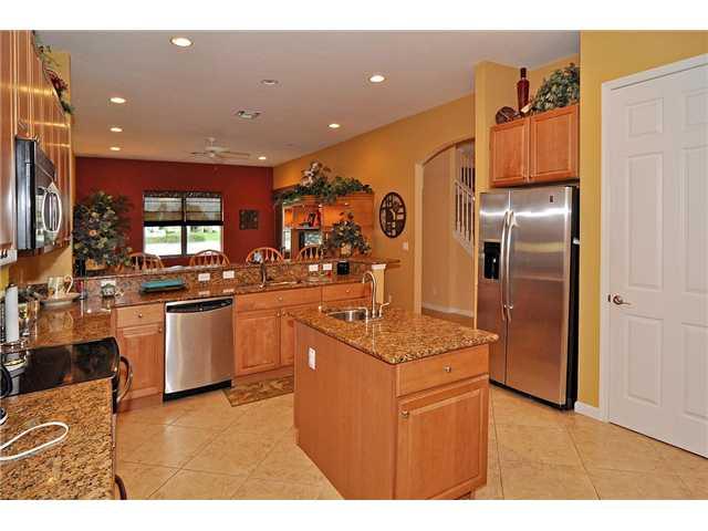 3152 Southwest Porpoise Circle Stuart, FL 34997 - Photo 8 of 19 a kitchen with kitchen island granite countertop a refrigerator oven a sink and dishwasher