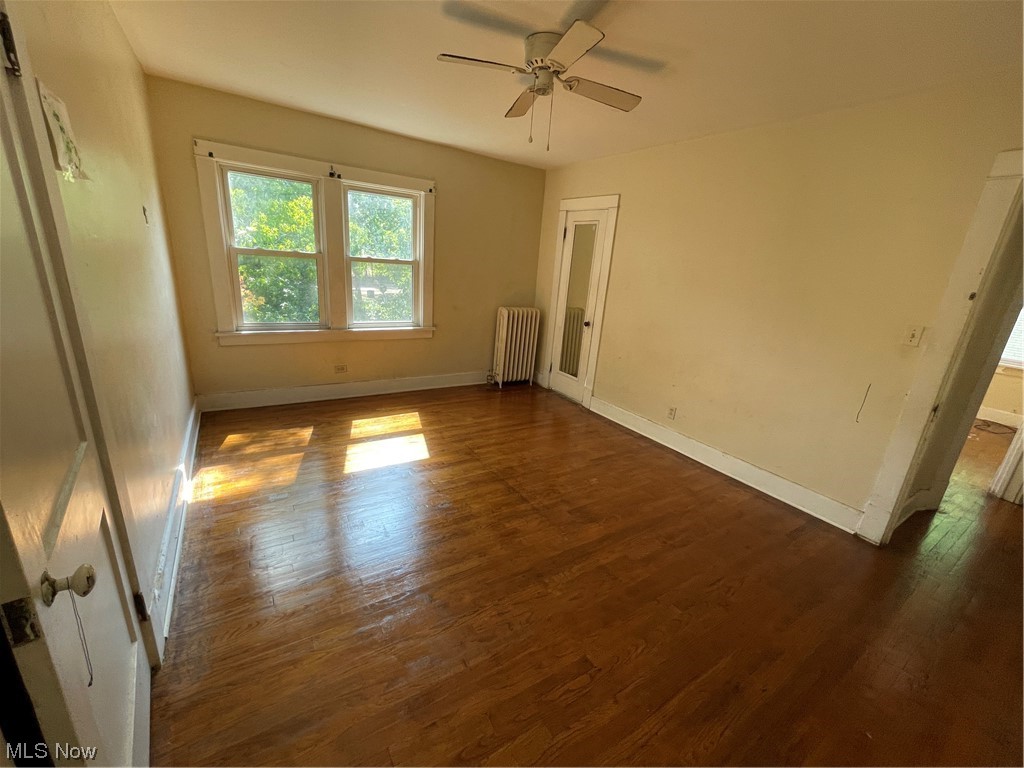 1730 Wood Road Cleveland Heights, OH 44121 - Photo 25 of 34 Spare room with ceiling fan, radiator heating unit, and dark hardwood floors