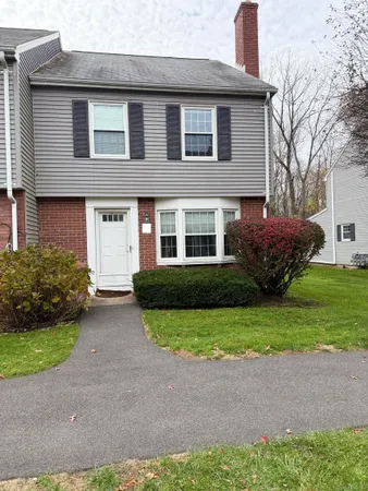 a front view of a house with a garden and plants