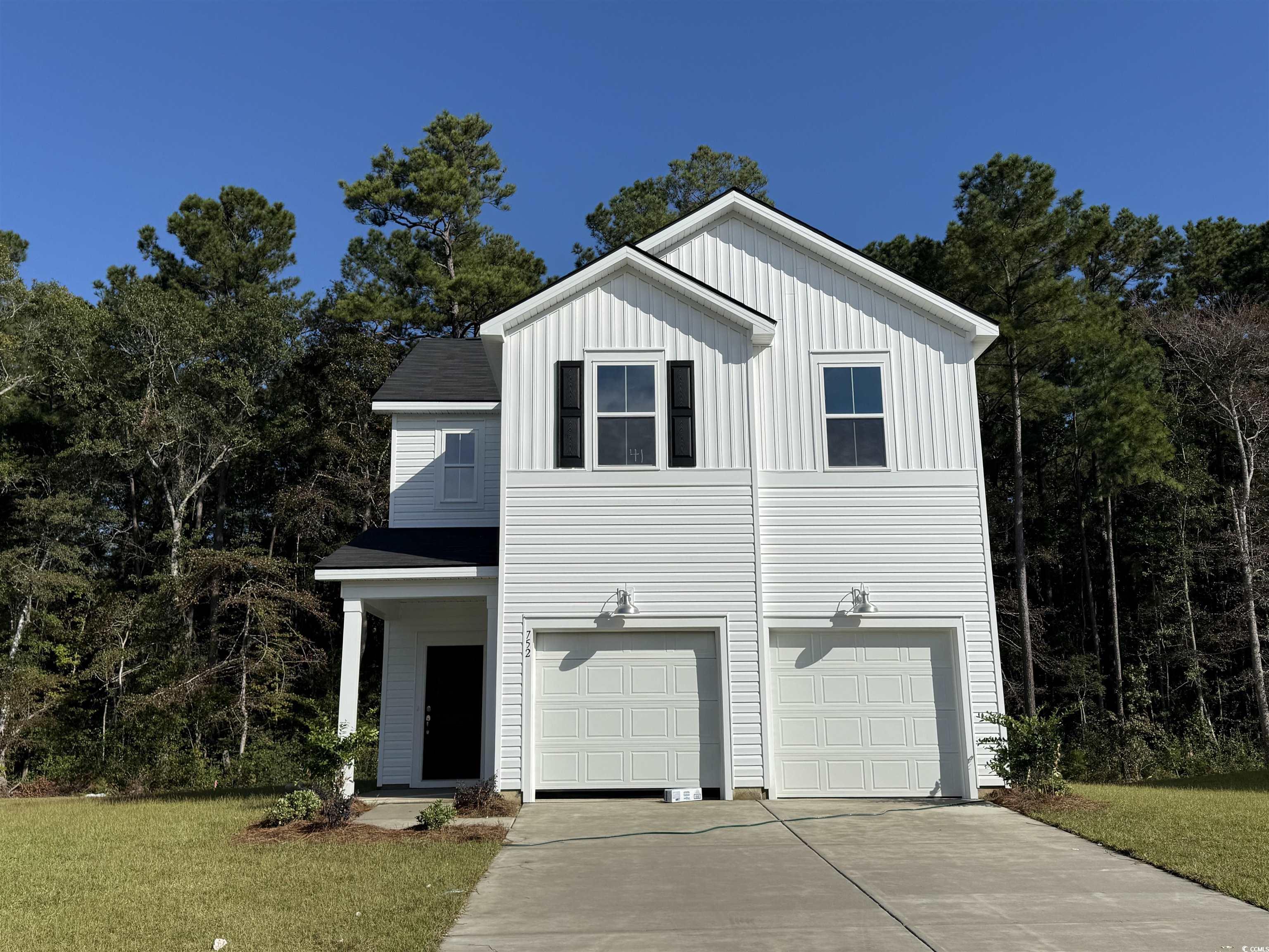 752 Sturdy Root Place Myrtle Beach, SC 29588 - Photo 1 of 19 View of front of property with board and batten siding, an attached garage, a front yard, and driveway