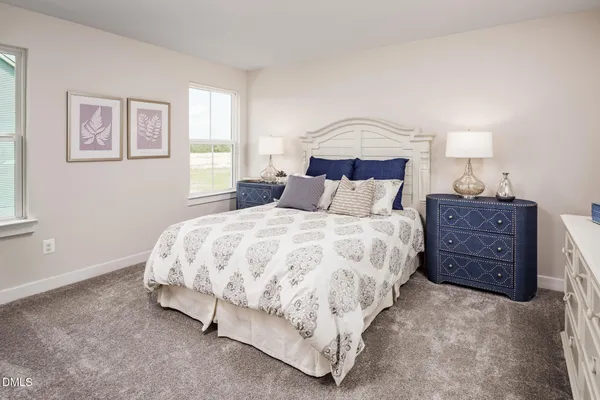 a bedroom with a bed a lamp and a window