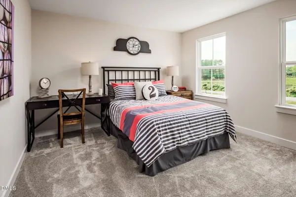 a bedroom with a bed and a table in it next to a window