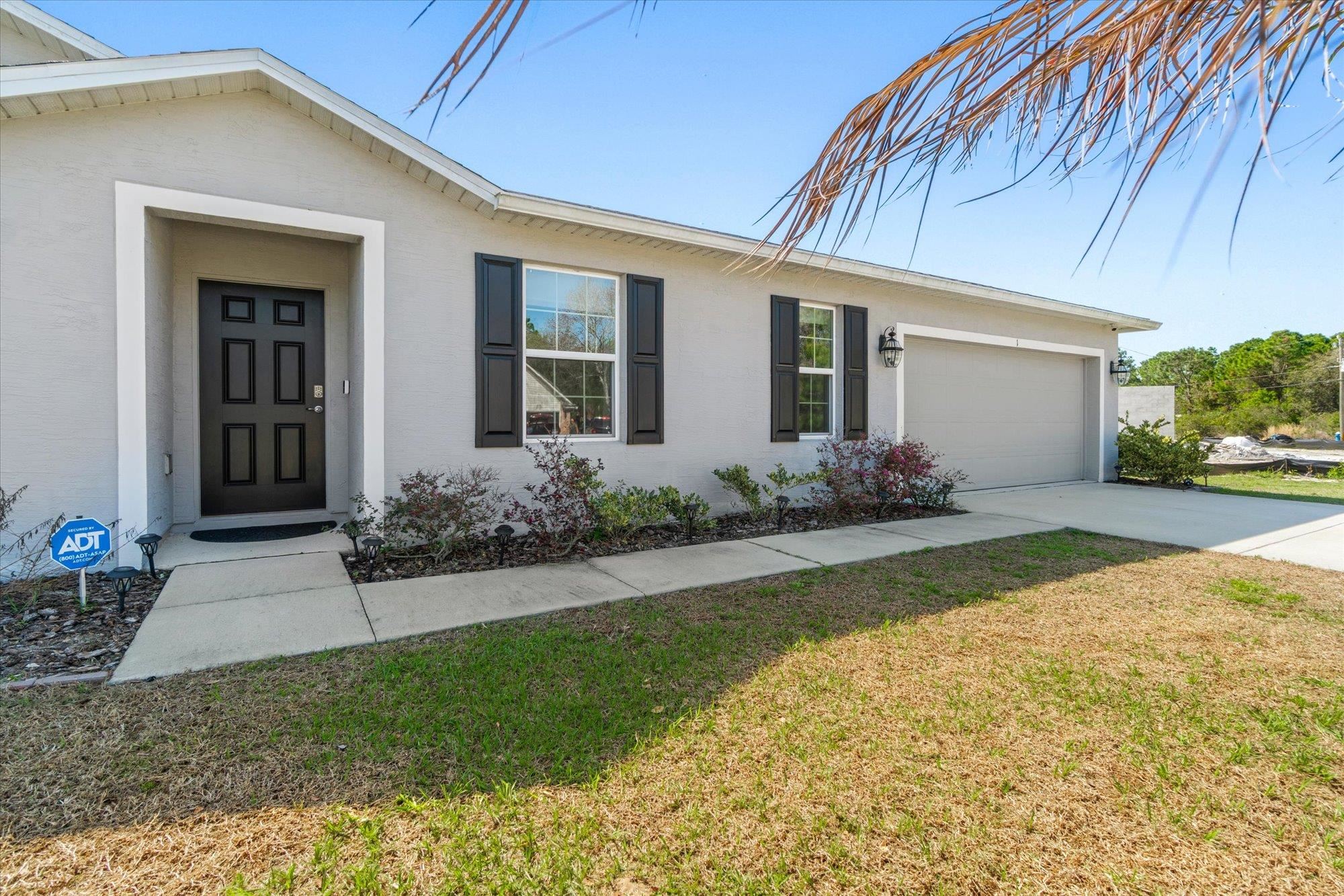 1 Frenora Lane Palm Coast, FL 32137 - Photo 31 of 43 View of front of home with a garage, a front yard, and concrete driveway