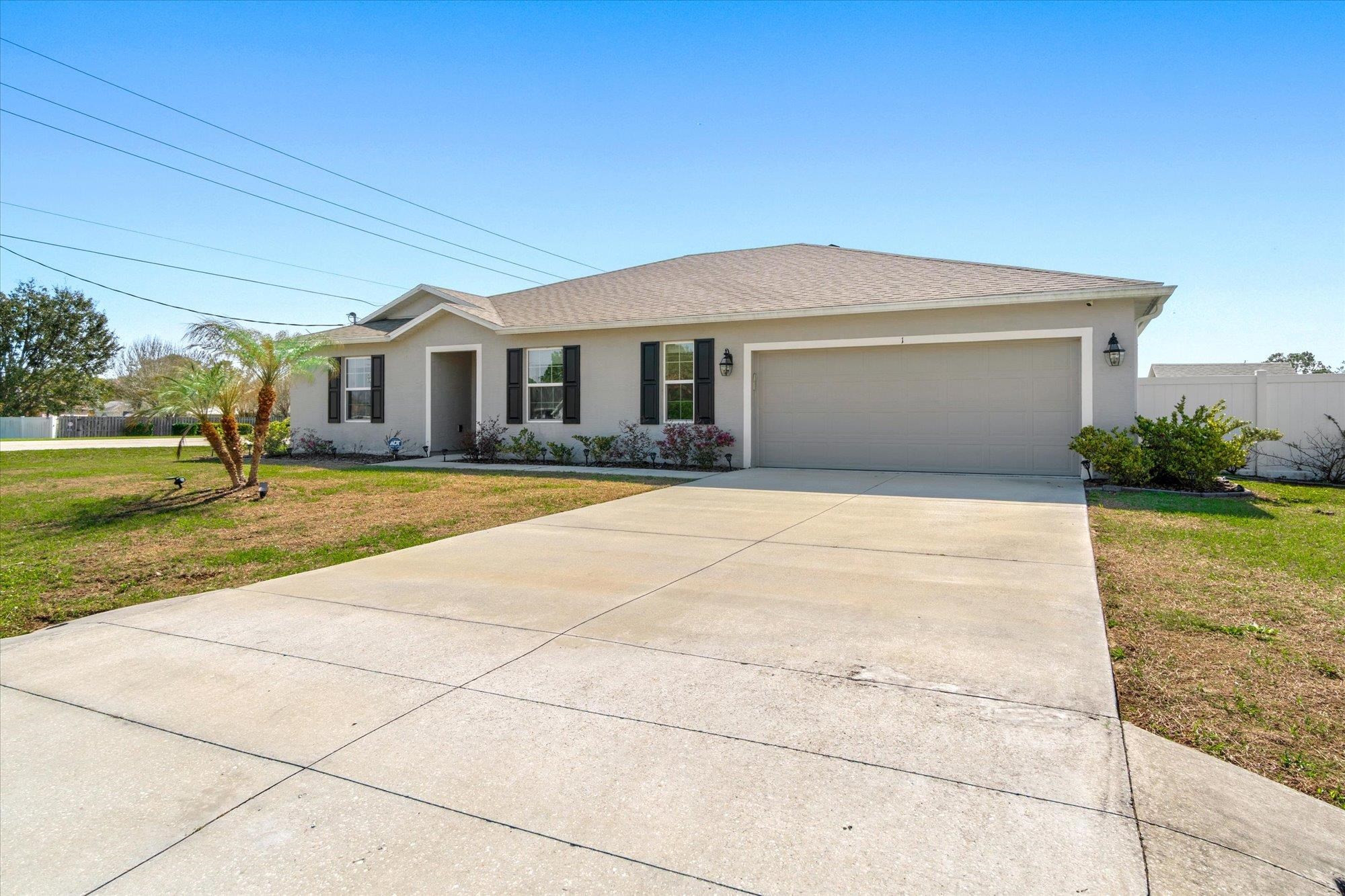 1 Frenora Lane Palm Coast, FL 32137 - Photo 33 of 43 Single story home featuring stucco siding, concrete driveway, an attached garage, and a shingled roof