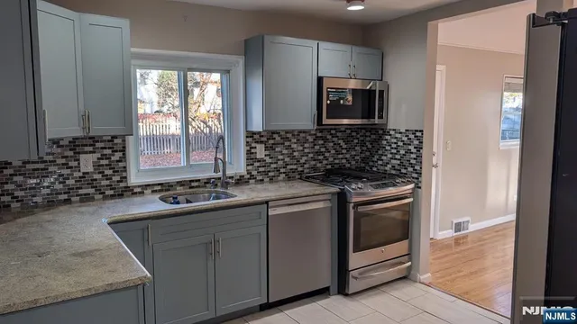 a kitchen with sink stove and refrigerator