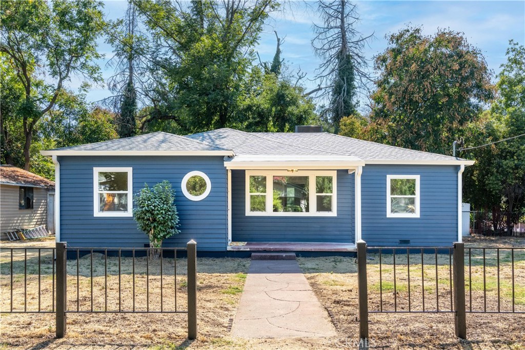 a front view of a house with a tree