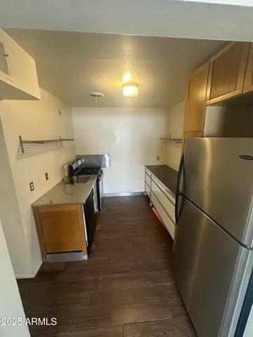 a walk in closet with wooden floor