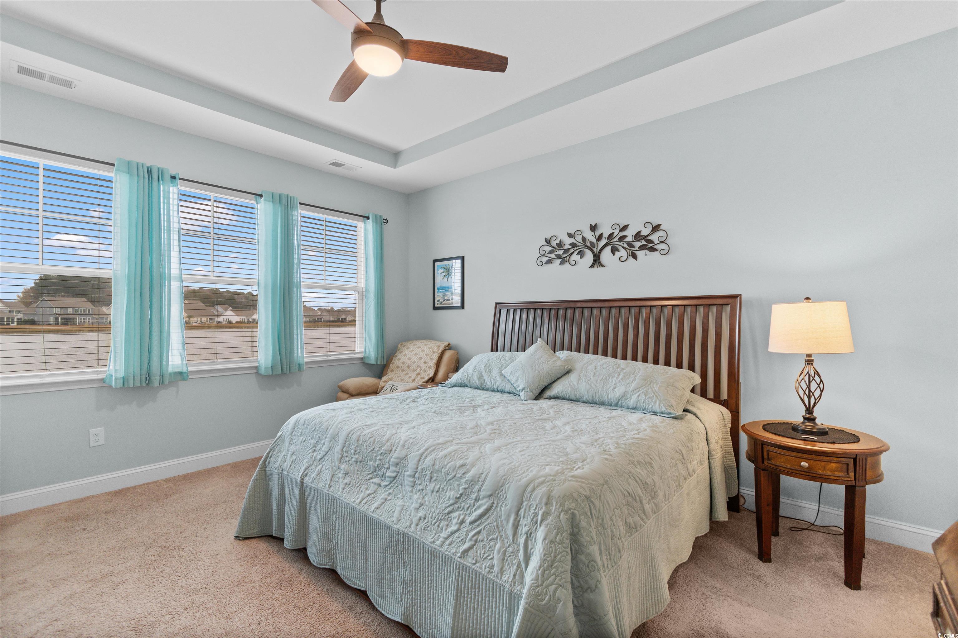 4842 Timberlake Drive Myrtle Beach, SC 29588 - Photo 4 of 38 Bedroom featuring light carpet, ceiling fan, and a raised ceiling