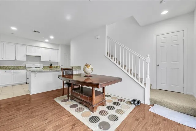 a living room with stainless steel appliances kitchen island granite countertop a stove a sink a refrigerator and cabinets