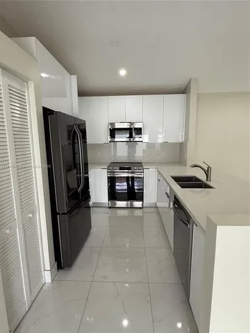 a kitchen with stainless steel appliances granite countertop a refrigerator and a stove top oven
