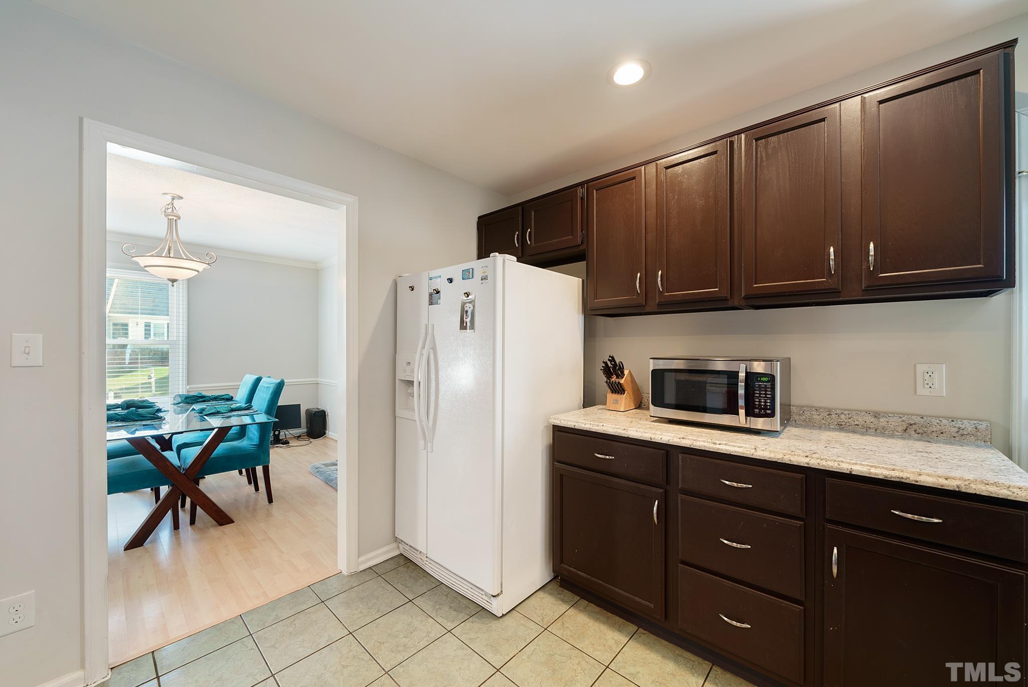 8205 Bellingham Circle Raleigh, NC 27615 - Photo 11 of 16 a kitchen with a refrigerator a stove a sink and a cabinets