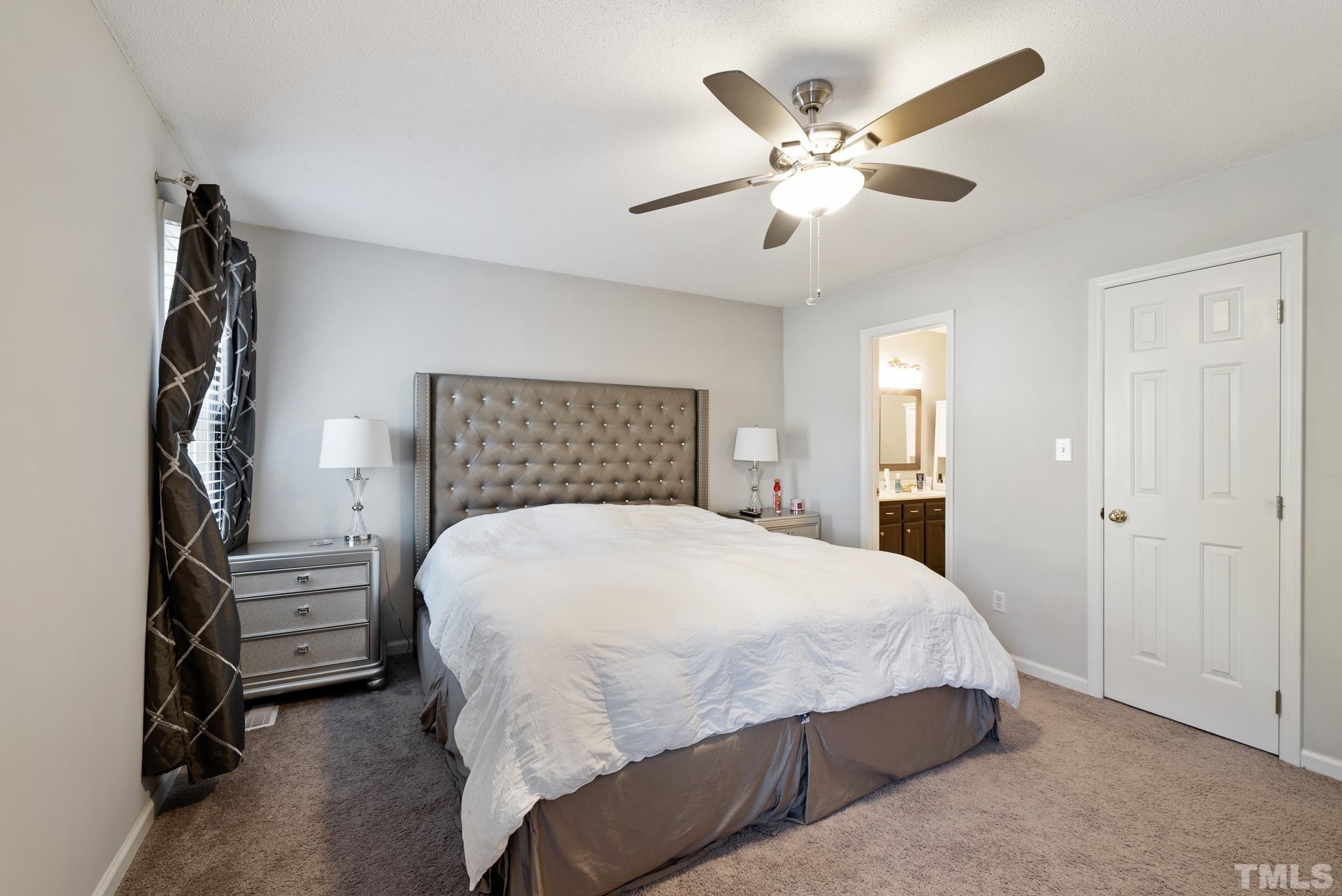 8205 Bellingham Circle Raleigh, NC 27615 - Photo 15 of 16 a bedroom with a large bed and a ceiling fan