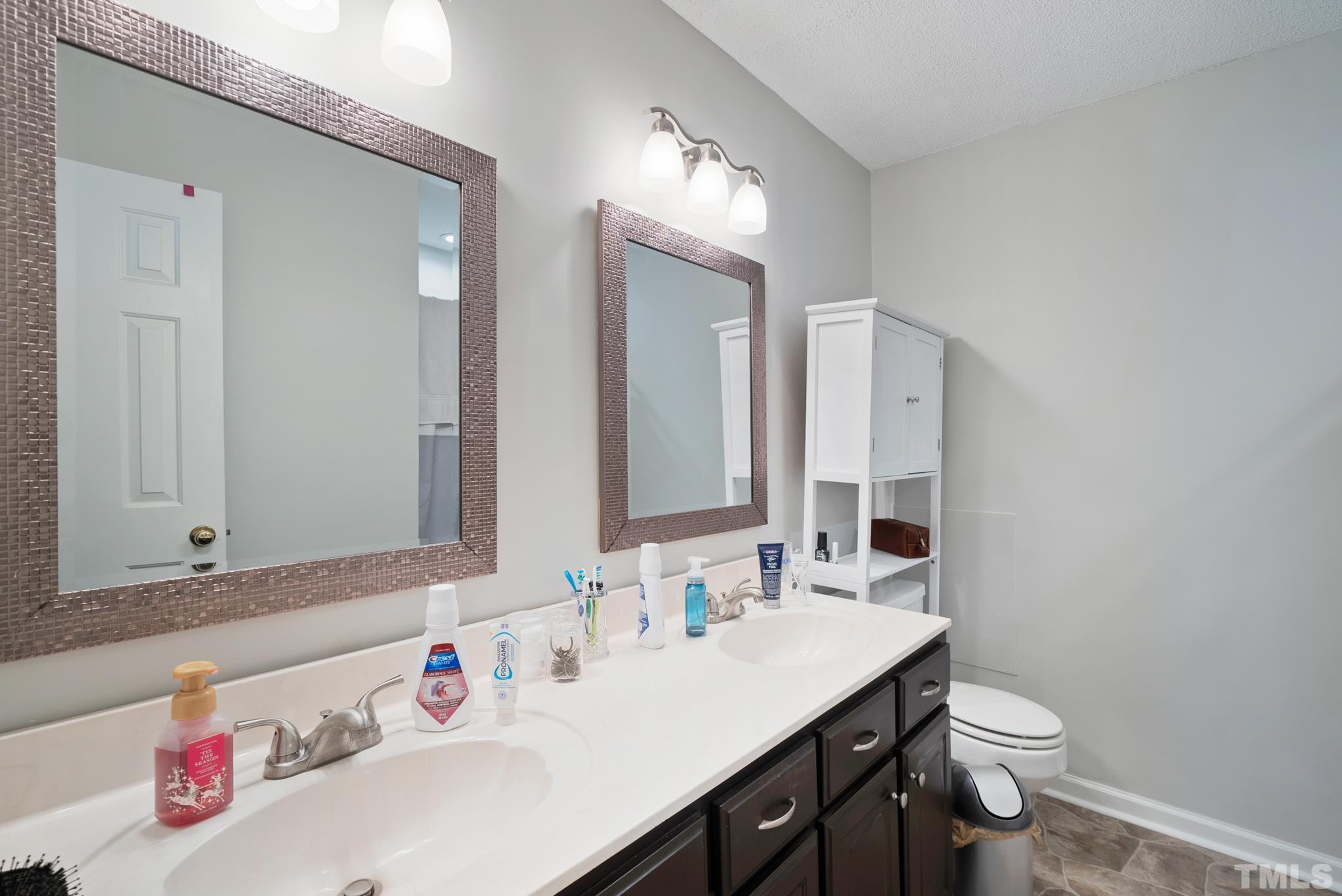 8205 Bellingham Circle Raleigh, NC 27615 - Photo 16 of 16 a bathroom with a sink a toilet and a mirror