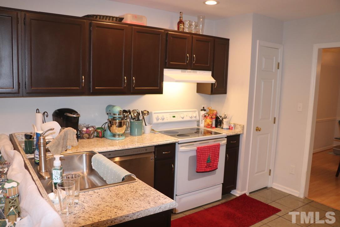 8205 Bellingham Circle Raleigh, NC 27615 - Photo 7 of 16 a kitchen with stainless steel appliances granite countertop a sink stove and cabinets