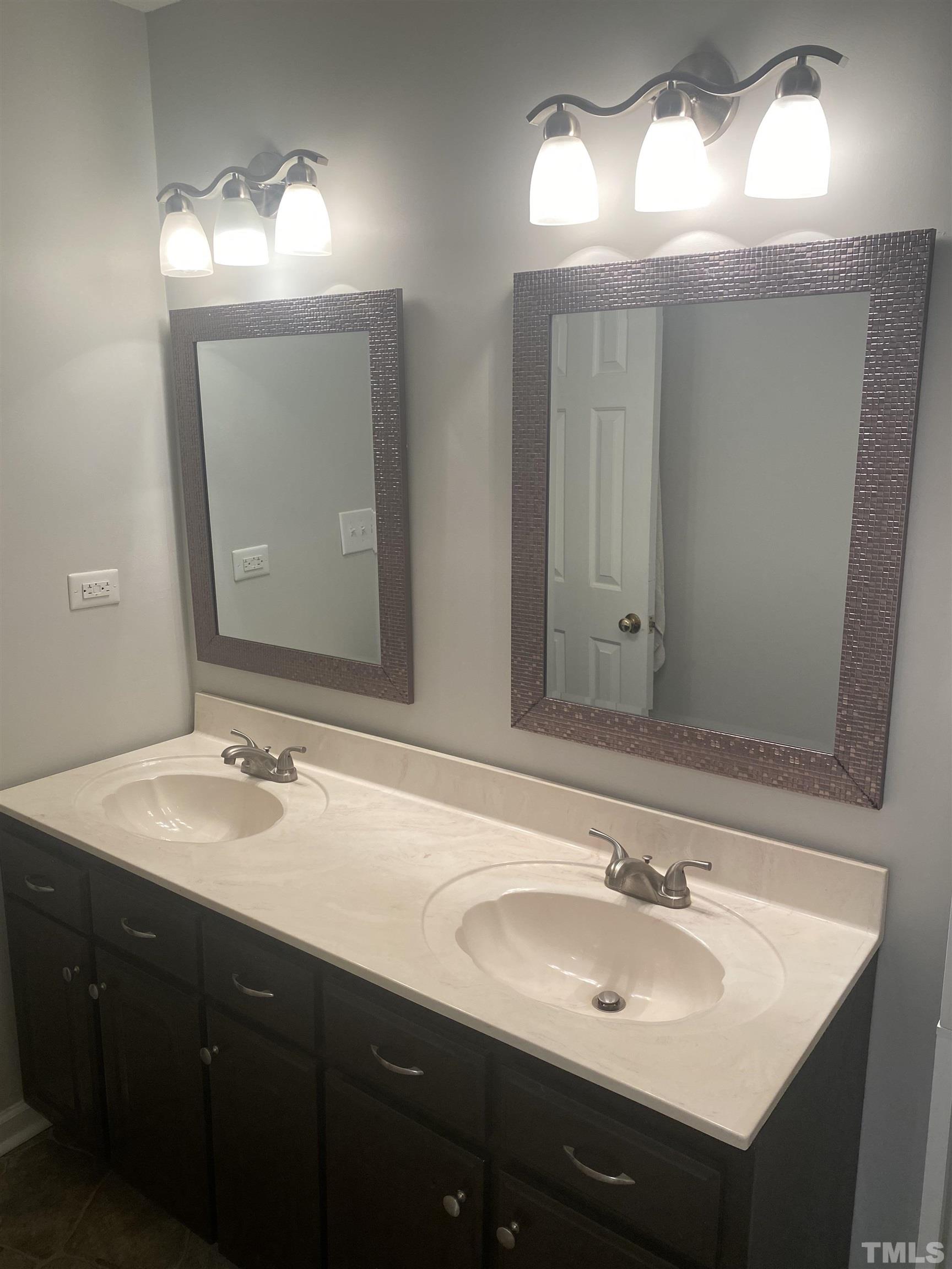8205 Bellingham Circle Raleigh, NC 27615 - Photo 9 of 16 a bathroom with double sink and a mirror