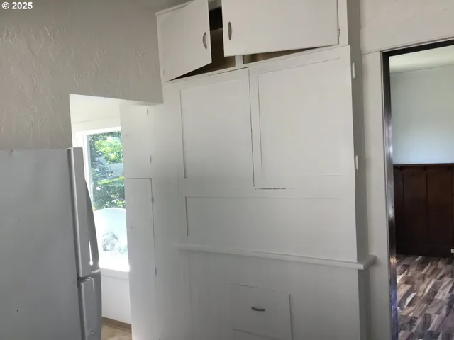 a kitchen with white cabinets and white appliances