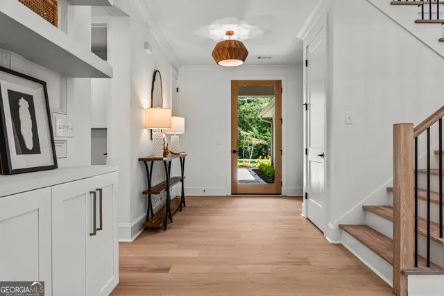 a living room with furniture kitchen view and a wooden floor