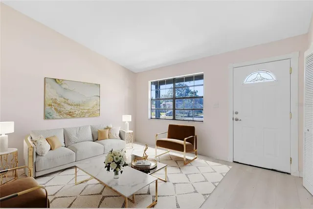 a living room with furniture a flat screen tv and a window