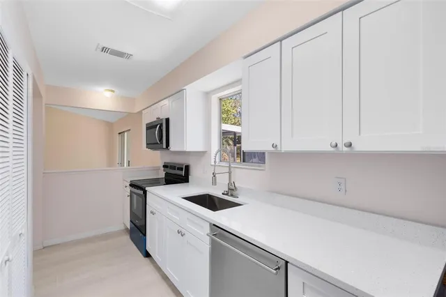 a kitchen with a sink cabinets and appliances