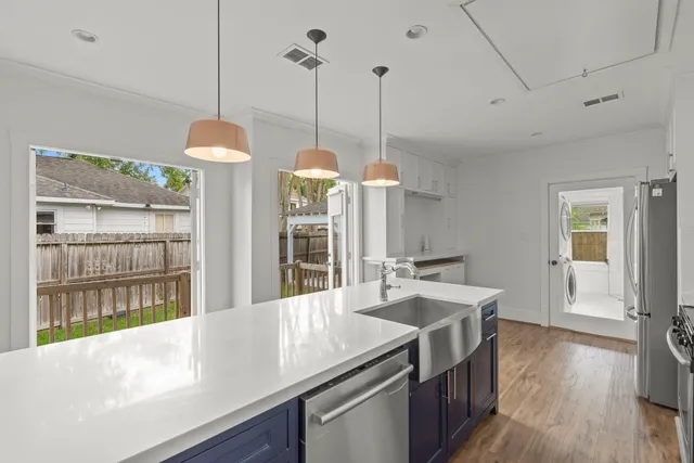 a kitchen with a sink stove and wooden floor