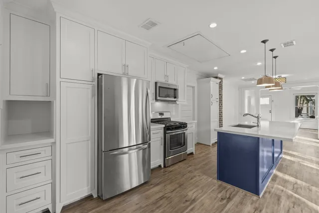 a kitchen with stainless steel appliances granite countertop a refrigerator a stove a sink and a refrigerator