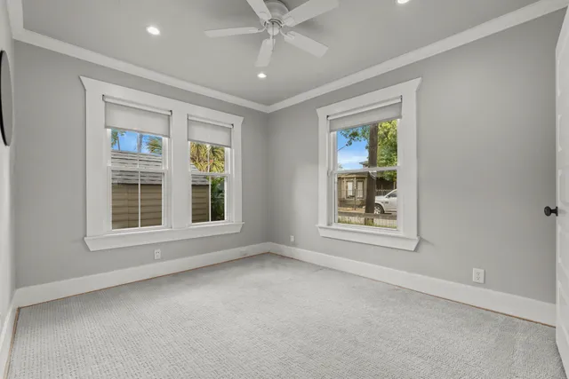 an empty room with a ceiling fan and a window