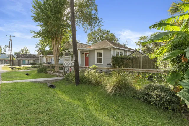 a view of a house with a yard patio and tree