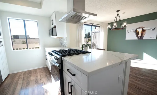 a kitchen with a sink a stove and wooden floor