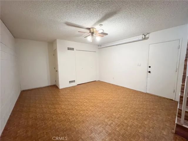 an empty room with closet and chandelier fan