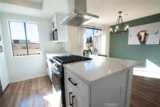 a kitchen with a sink a stove and wooden floor