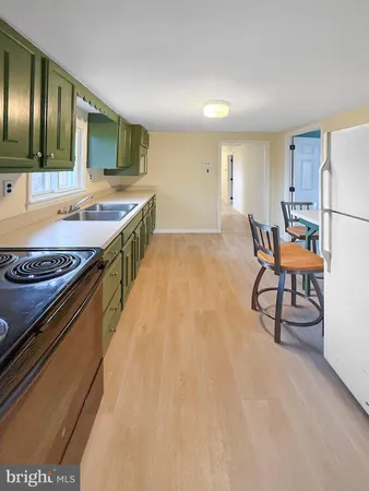 a kitchen with stainless steel appliances granite countertop a table chairs sink and cabinets