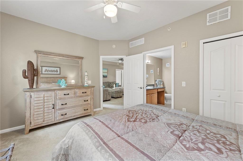 12955 Positano Circle, Unit 104 Naples, FL 34105 - Photo 12 of 40 a bedroom with a bed and a dresser