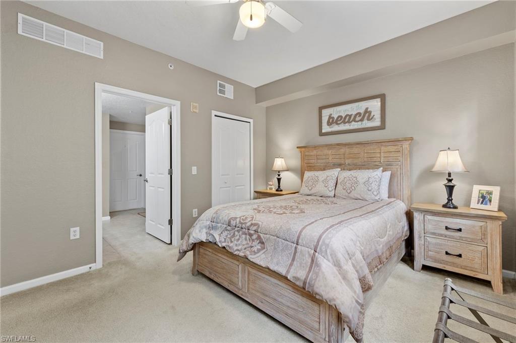 12955 Positano Circle, Unit 104 Naples, FL 34105 - Photo 14 of 40 a bedroom with a bed and a chandelier