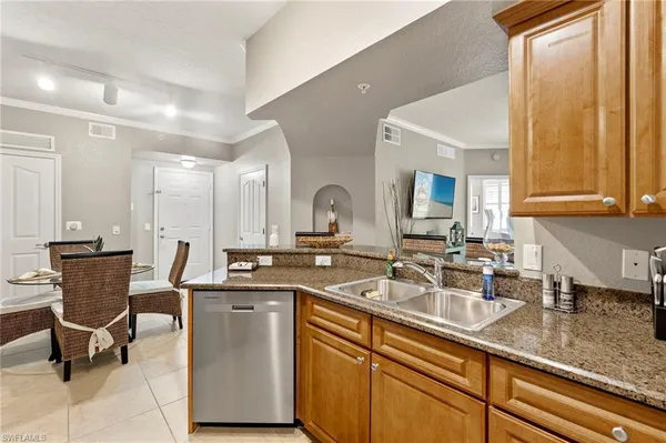 a kitchen with a sink and chairs