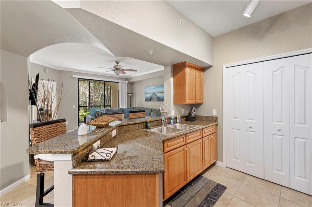 12955 Positano Circle, Unit 104 Naples, FL 34105 - Photo 8 of 40 a spacious bathroom with a granite countertop sink and a mirror
