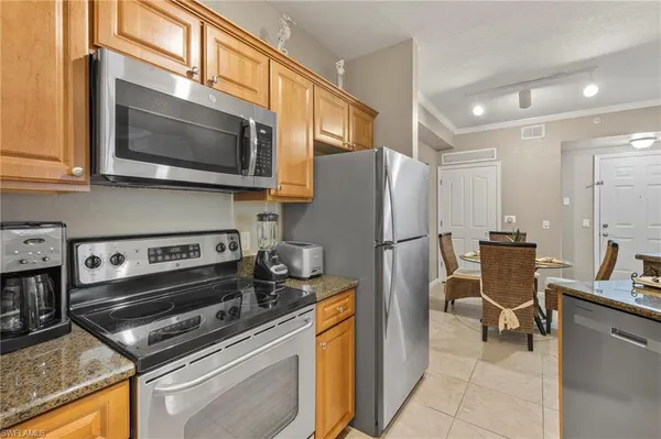 a kitchen with stainless steel appliances granite countertop a stove a refrigerator and a microwave