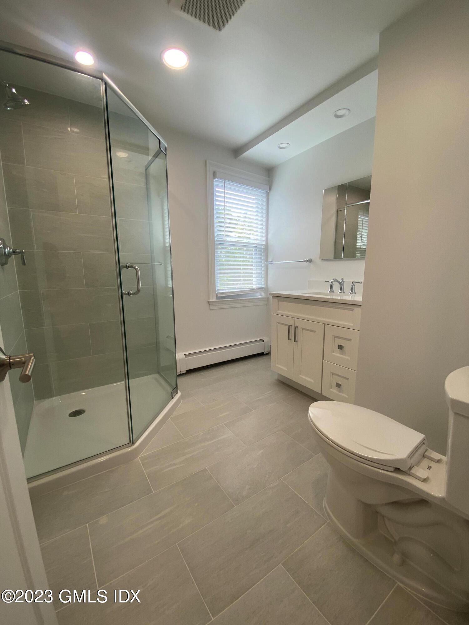 36 Arch Street, Unit 2A Greenwich, CT 06830 - Photo 5 of 7 a bathroom with a granite countertop sink toilet and shower