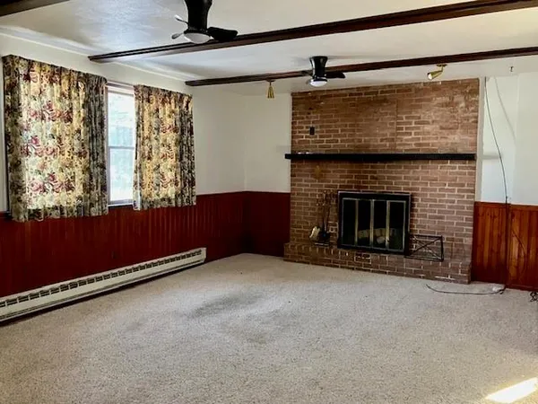 a view of an empty room with a fireplace and a window